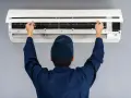 Tecnico controlla un condizionatore che non raffredda, aprendo il pannello frontale per ispezionare i filtri.