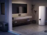 Bagno moderno con scaldabagno elettrico bianco, unità esterna e lavabo. La temperatura massima dello scaldabagno elettrico è regolabile.
