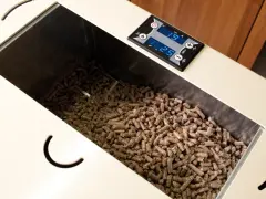 Serbatoio pieno di pellet, alcuni sembrano un po' troppo lunghi per la stufa. Il display digitale mostra 19 e 25.