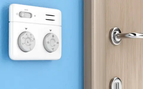 Termostato bianco su muro blu, parte di moderni sistemi di termoregolazione, con manopole per temperatura e modalità.