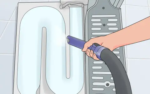 Mano che usa un aspirapolvere per pulire il bruciatore della caldaia, rimuovendo polvere e detriti per un funzionamento efficiente.