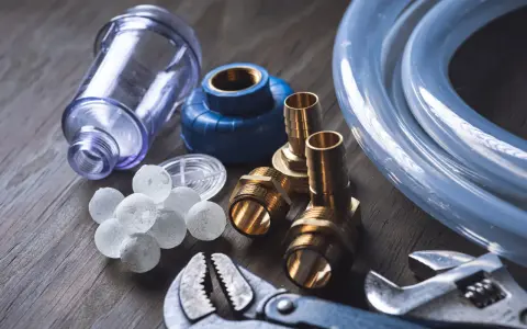 Componenti per caldaia: filtro, raccordi, tubo e palline per addolcitore. Utili per capire ogni quanto cambiare sali caldaia.