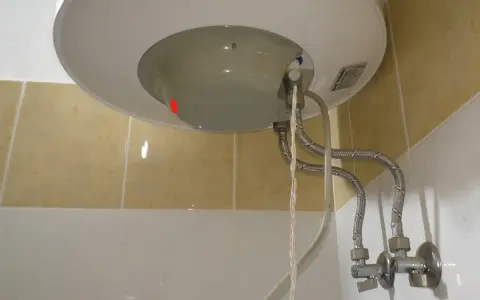 Dettaglio del fondo di uno scaldabagno con tubi flessibili e valvola di sicurezza. Guida su come regolare valvola di sicurezza scaldabagno.