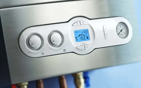 Caldaia moderna con display digitale che mostra la temperatura e la pressione acqua termosifoni.