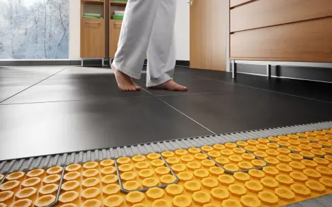 Piedi nudi su un pavimento piastrellato, con un sistema di riscaldamento ad aria calda visibile sotto.