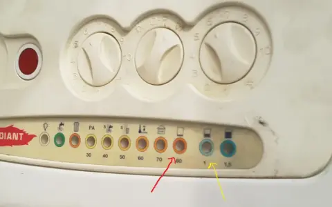 Pannello caldaia con manopole e spie. La spia rossa fissa indica un problema.