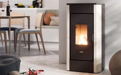 Stufa a pellet moderna in funzione, con fiamme vive. L'installazione stufa a pellet con canna fumaria è discreta, integrata in un ambiente cucina/soggiorno accogliente.