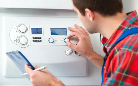 Tecnico regola la caldaia. Speriamo che l'acqua calda ci metta tanto ad arrivare.