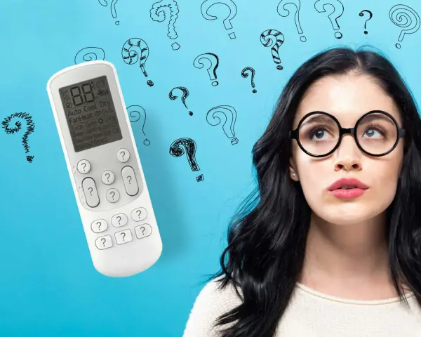 Ragazza con occhiali guarda telecomando condizionatore, circondata da punti interrogativi. Cosa significa "swing"?