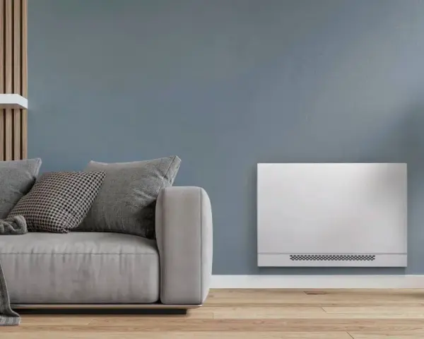 Soggiorno moderno con divano grigio e un elegante termoconvettore ad acqua al posto del termosifone, che diffonde calore in modo discreto.