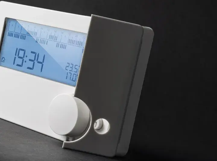 Cronotermostato cos'è? Un dispositivo digitale bianco con display blu che mostra ora, temperatura e programmazione.