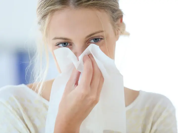 Donna con fazzoletto nasale, forse soffre di allergia aria condizionata.