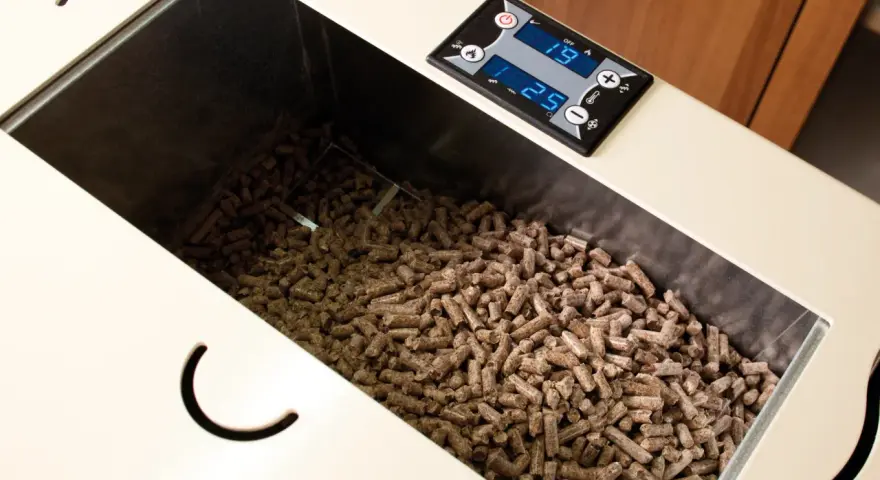 Serbatoio pieno di pellet, alcuni sembrano un po' troppo lunghi per la stufa. Il display digitale mostra 19 e 25.
