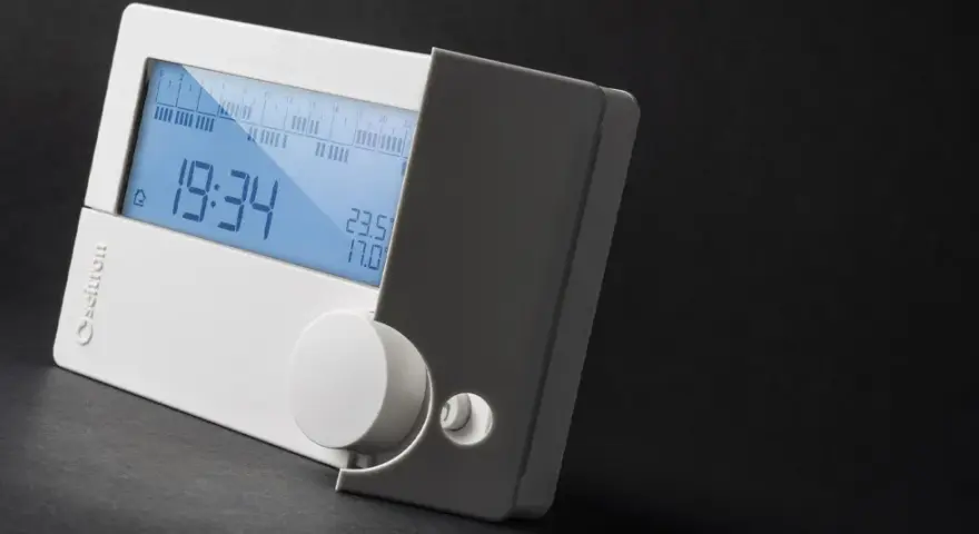 Cronotermostato cos'è? Un dispositivo digitale bianco con display blu che mostra ora, temperatura e programmazione.