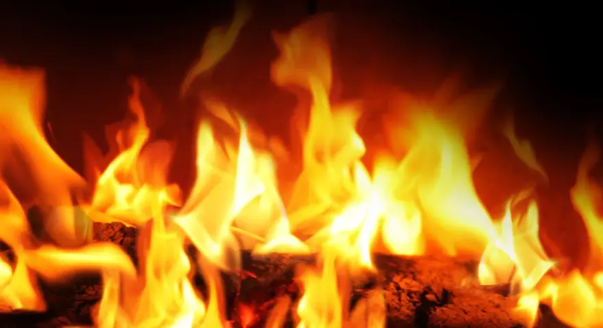 Fiamme vivaci danzano su legna ardente. La stufa a pellet si accende da sola, creando un'atmosfera calda e accogliente.