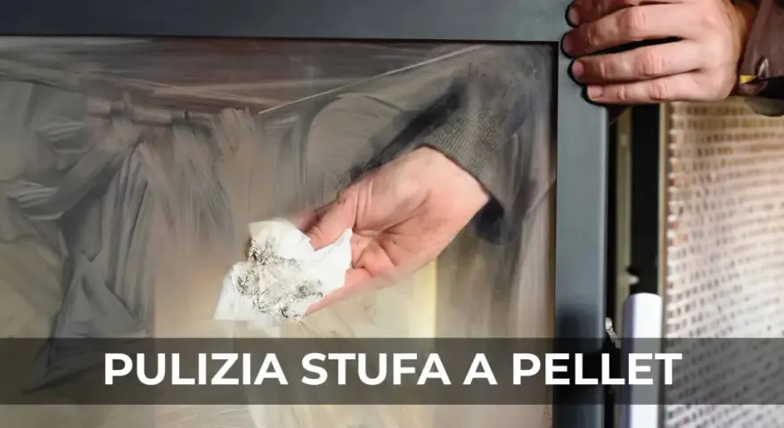 Mano che pulisce il vetro di una stufa a pellet con un panno sporco di fuliggine.