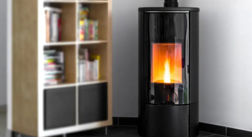 Stufa a pellet moderna con fiamma viva, ideale per dormire con la stufa a pellet accesa in un ambiente accogliente, accanto a una libreria.