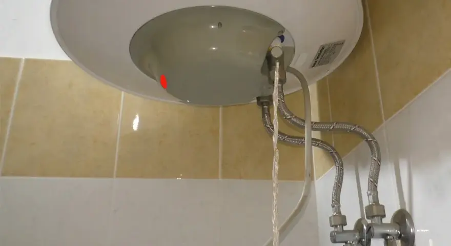 Dettaglio del fondo di uno scaldabagno con tubi flessibili e valvola di sicurezza. Guida su come regolare valvola di sicurezza scaldabagno.