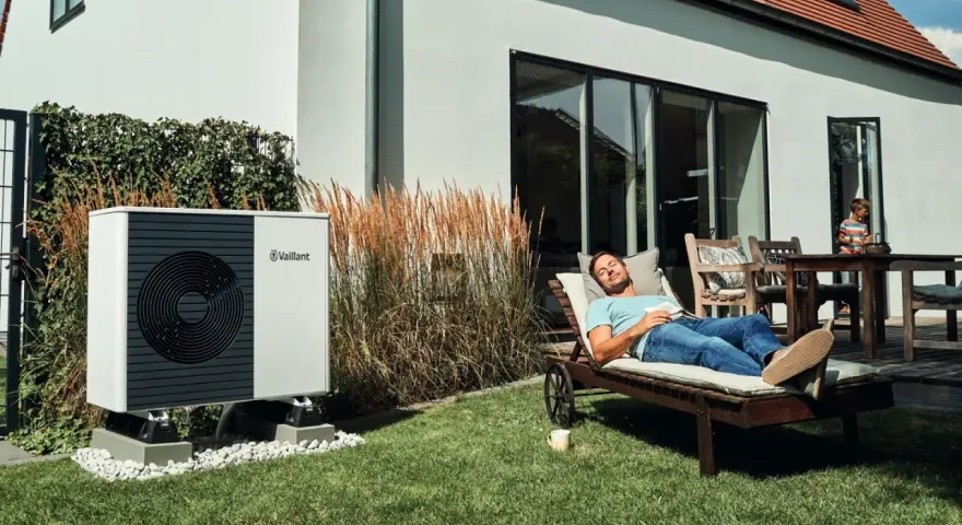 Pompa di calore Vaillant, silenziosa e discreta, permette a un uomo di rilassarsi in giardino senza sentire alcun rumore strano.