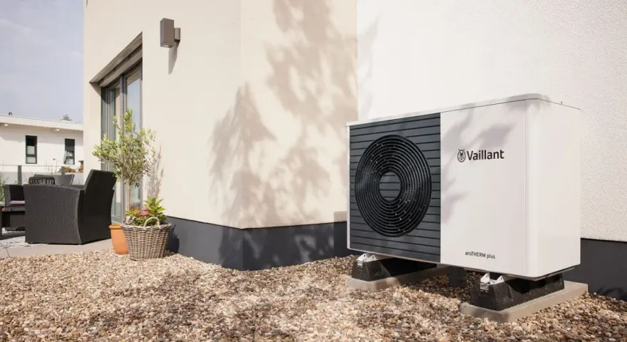 Unità esterna Vaillant per raffrescamento con termosifoni, posizionata su ghiaia vicino a una casa moderna.