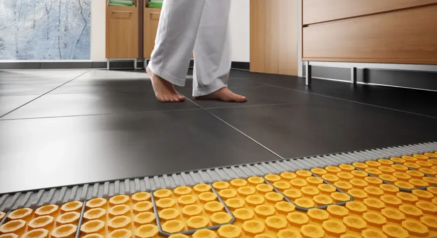 Piedi nudi su un pavimento piastrellato, con un sistema di riscaldamento ad aria calda visibile sotto.