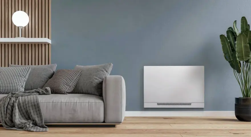 Soggiorno moderno con divano grigio e un elegante termoconvettore ad acqua al posto del termosifone, che diffonde calore in modo discreto.