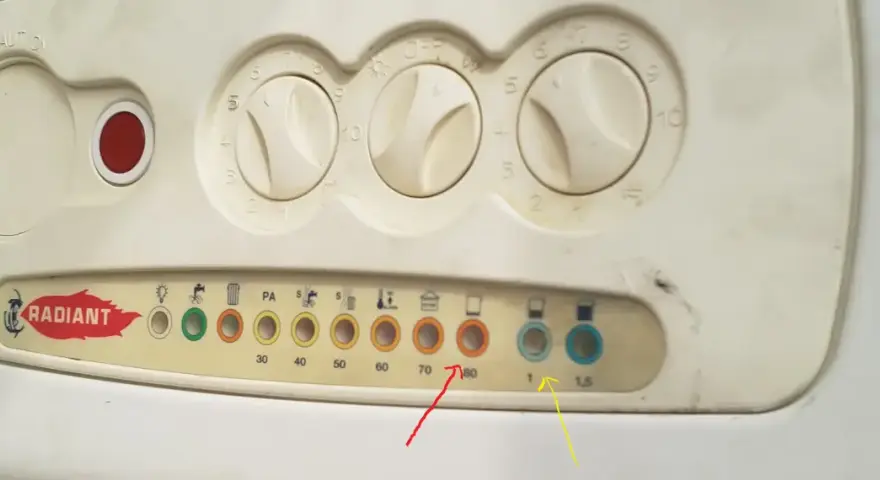Pannello caldaia con manopole e spie. La spia rossa fissa indica un problema.