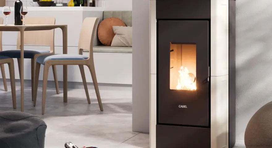 Stufa a pellet moderna in funzione, con fiamme vive. L'installazione stufa a pellet con canna fumaria è discreta, integrata in un ambiente cucina/soggiorno accogliente.