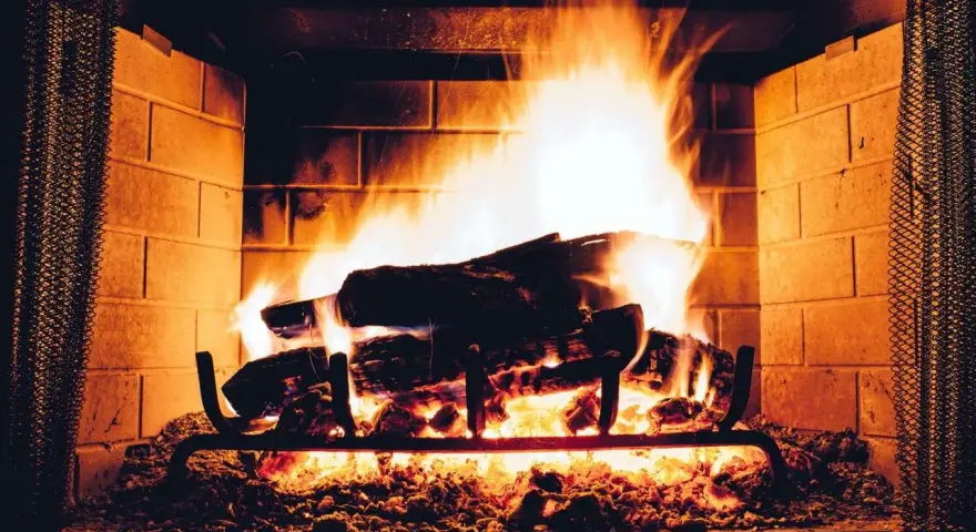 Legna che arde in un camino, con fiamme vivaci e un buon tiraggio presa aria camino che alimenta il fuoco.