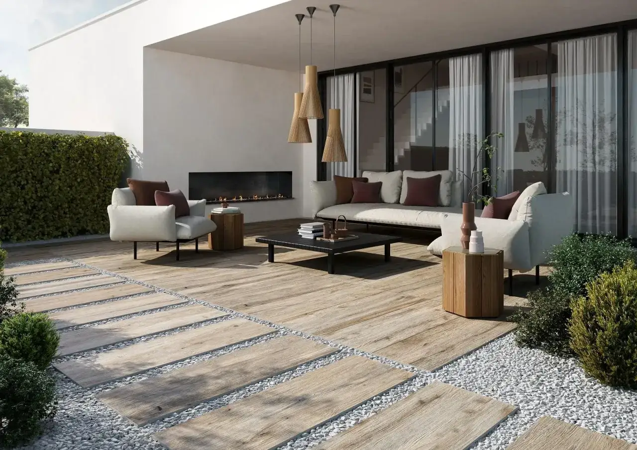 Un elegante terrazzo con un camino moderno, divani accoglienti e un pavimento effetto legno che ricorda il pavimento casa mare.