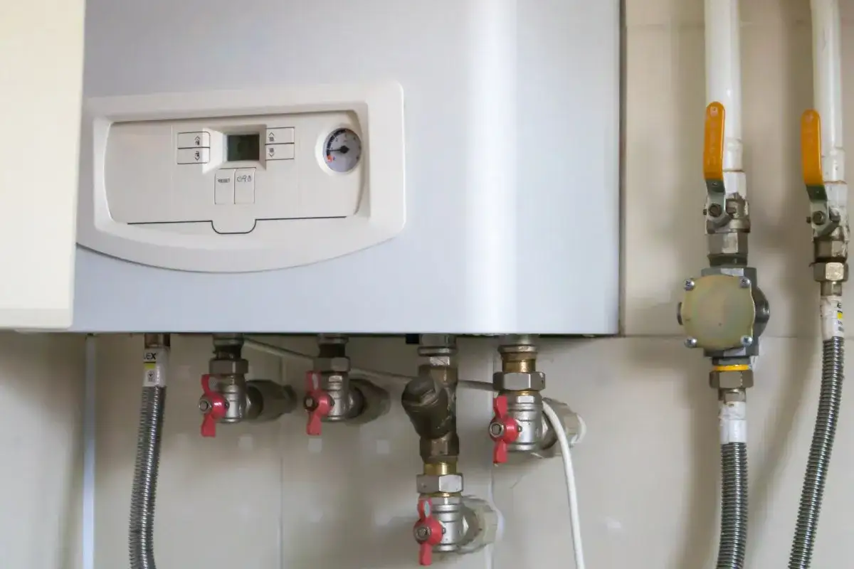 Caldaia a gas con pannello di controllo e tubazioni. Il tubo scarico fumi scaldabagno a gas normativa è essenziale per la sicurezza.